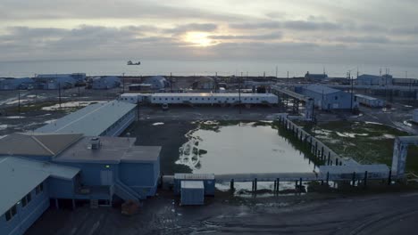 aerial drone shot flying over flooding climate research center in the thawed permafrost tundra with arctic ocean in background near barrow alaska