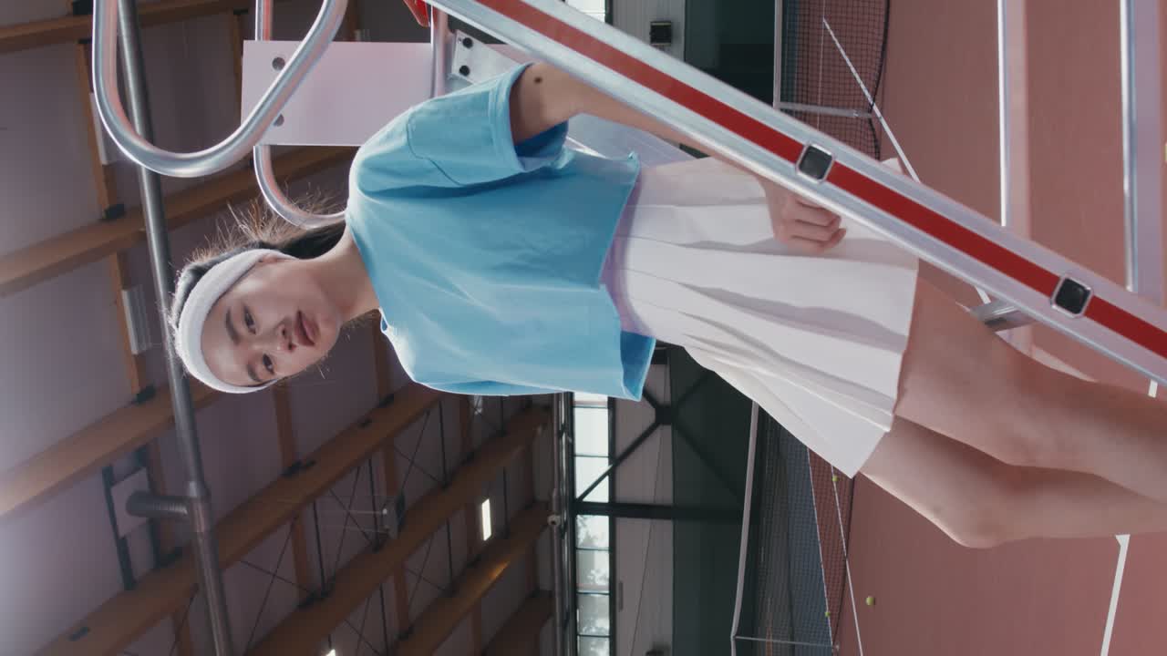 테니스 코트의 계단에서 포즈를 취하는 젊은 여성