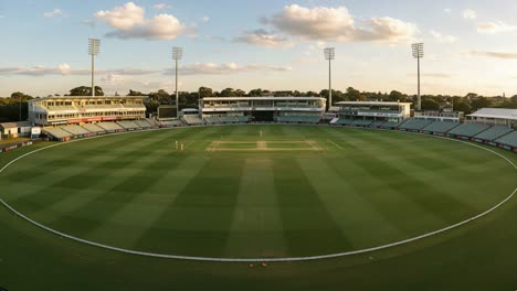 a stunning panoramic view of a cricket ground with lush green grass and clear skies, perfectly capturing the essence of outdoor sports environments
