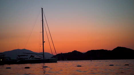 this shot depicts an evening view by the seaside in turkey, marmaris with a backdrop to some boats and mountains.