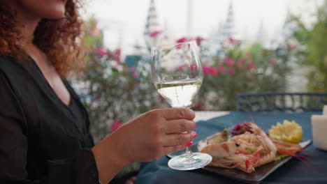 Woman thirsty During Lunch Picking Up A Glass Of White Wine At The Restaurant