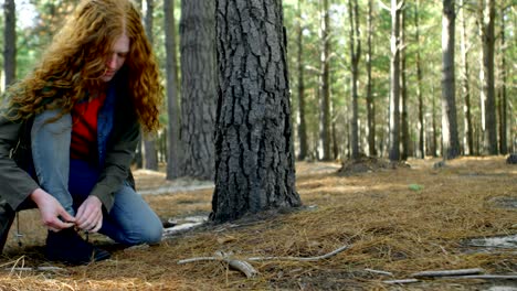 woman tying shoe laces in the forest 4k