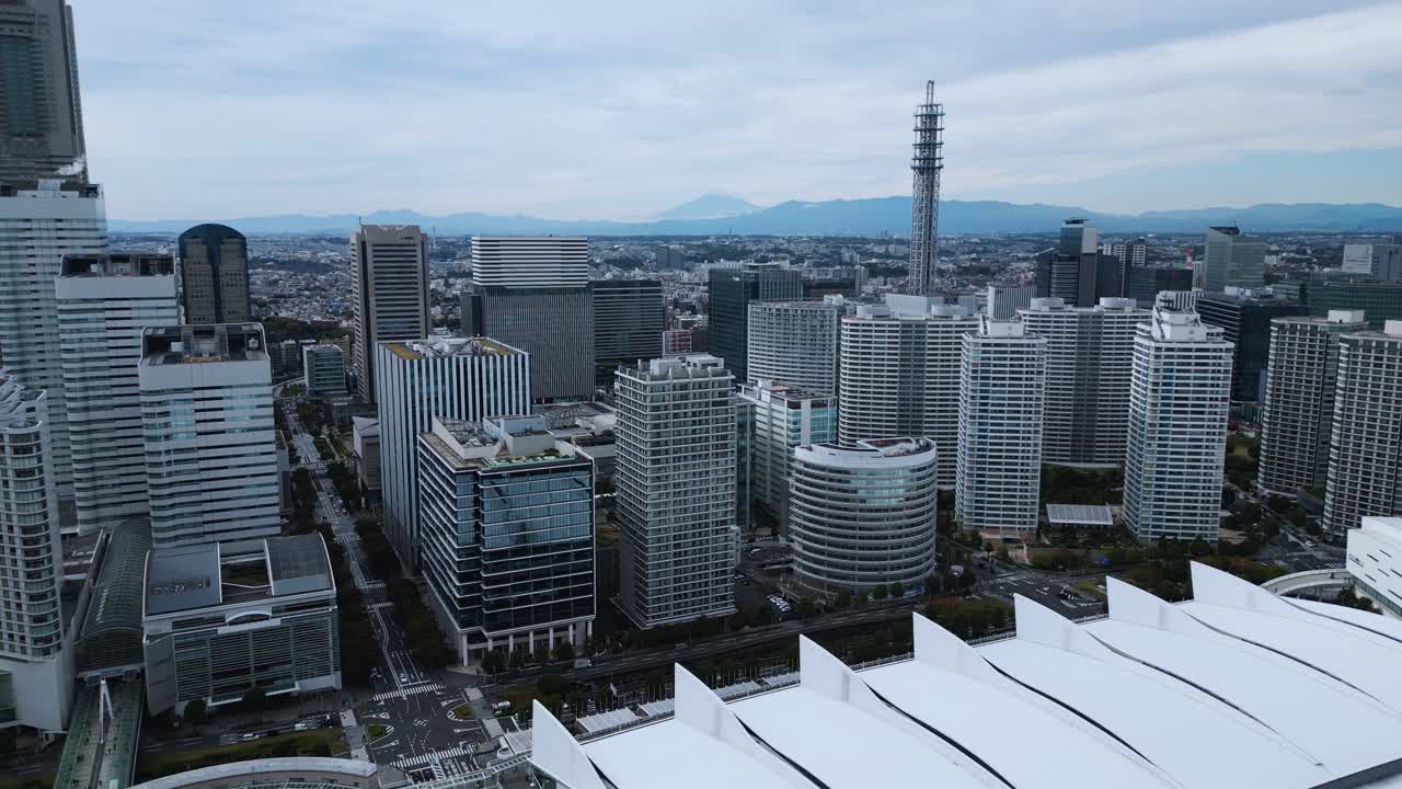 Drone moves backward over Yokohama skyline showing Fuji Mount and cool tones