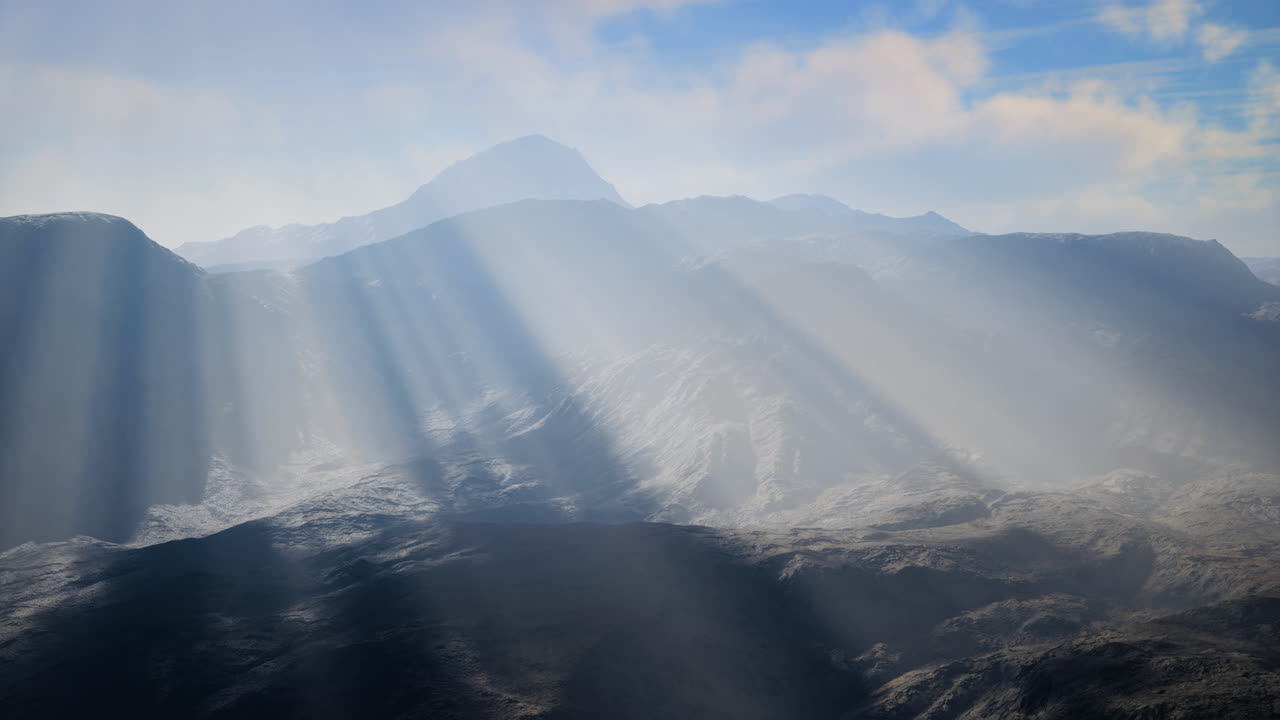 Light rays illuminate mountain landscape during early morning hours