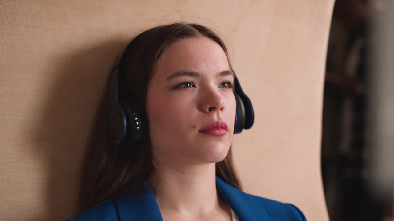 una mujer con auriculares escucha música de cerca en la biblioteca. una atractiva dama morena disfruta del material de aprendizaje de audiolibros en la universidad. tecnología de la educación