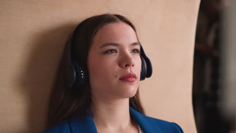 una mujer con auriculares escucha música de cerca en la biblioteca. una atractiva dama morena disfruta del material de aprendizaje de audiolibros en la universidad. tecnología de la educación