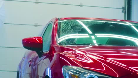 car washing cleaning with foam and high pressured water. red car