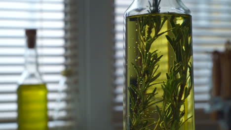 aceite de oliva con romero. hierba de romero cae en la botella de aceite de oliva
