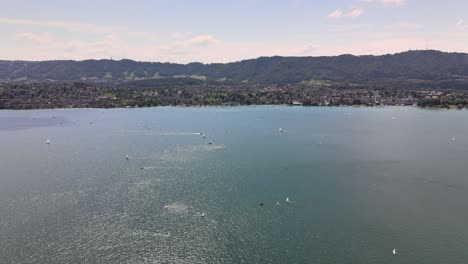 Drone-flyover-shot-over-Lake-Zürich-in-Switzerland-towards-Kilchberg