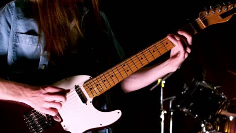 close up of man playing electric guitar