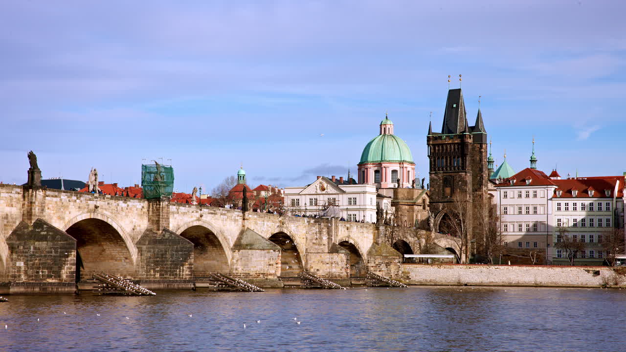 Il Ponte Carlo si inarca sul fiume Moldava nella città di Praga in una giornata di sole.