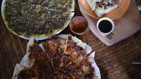 middle eastern or arabic dishes and assorted meze: hummus, pita, manakish lahm bi ajeen - flatbreads topped with minced meat and fatayer stuffed pie. halal food