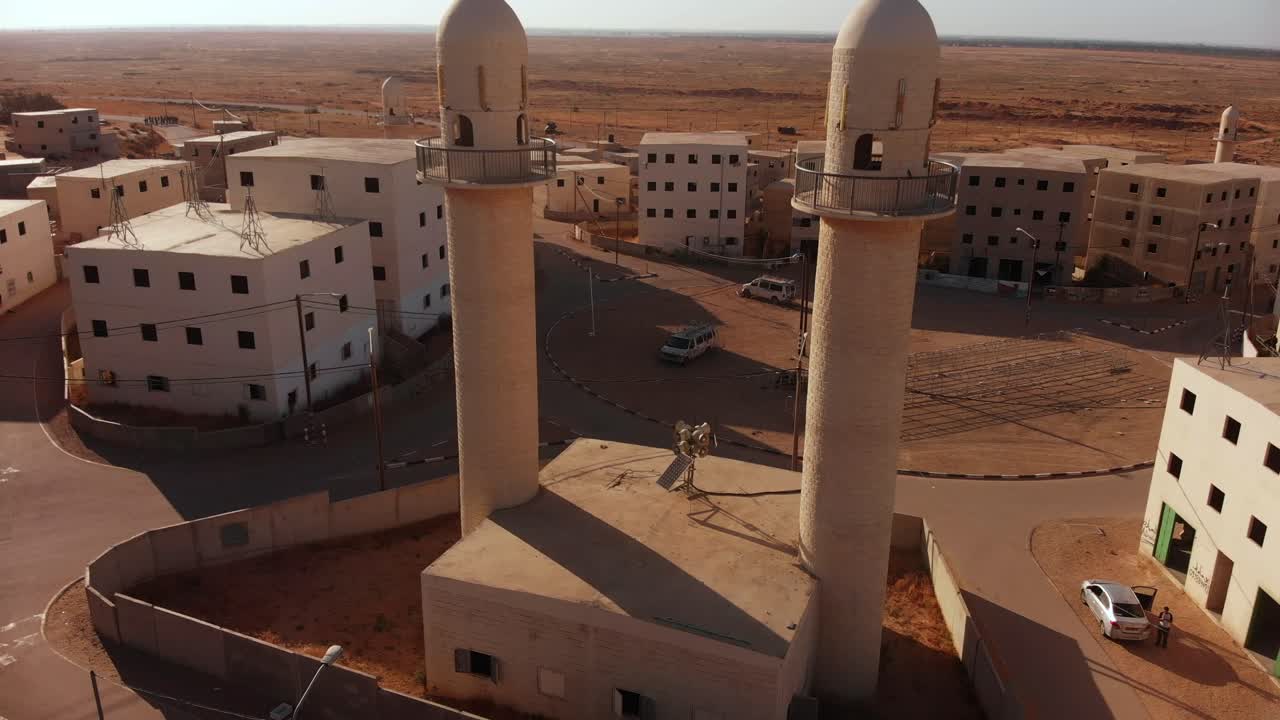 aerial shot of two mosques next to the main squere in an old empty city in the desert in palestine near Gaza at sunset