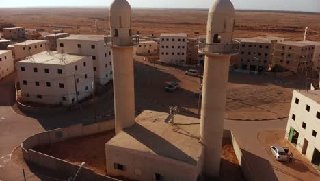 aerial shot of two mosques next to the main squere in an old empty city in the desert in palestine near gaza at sunset