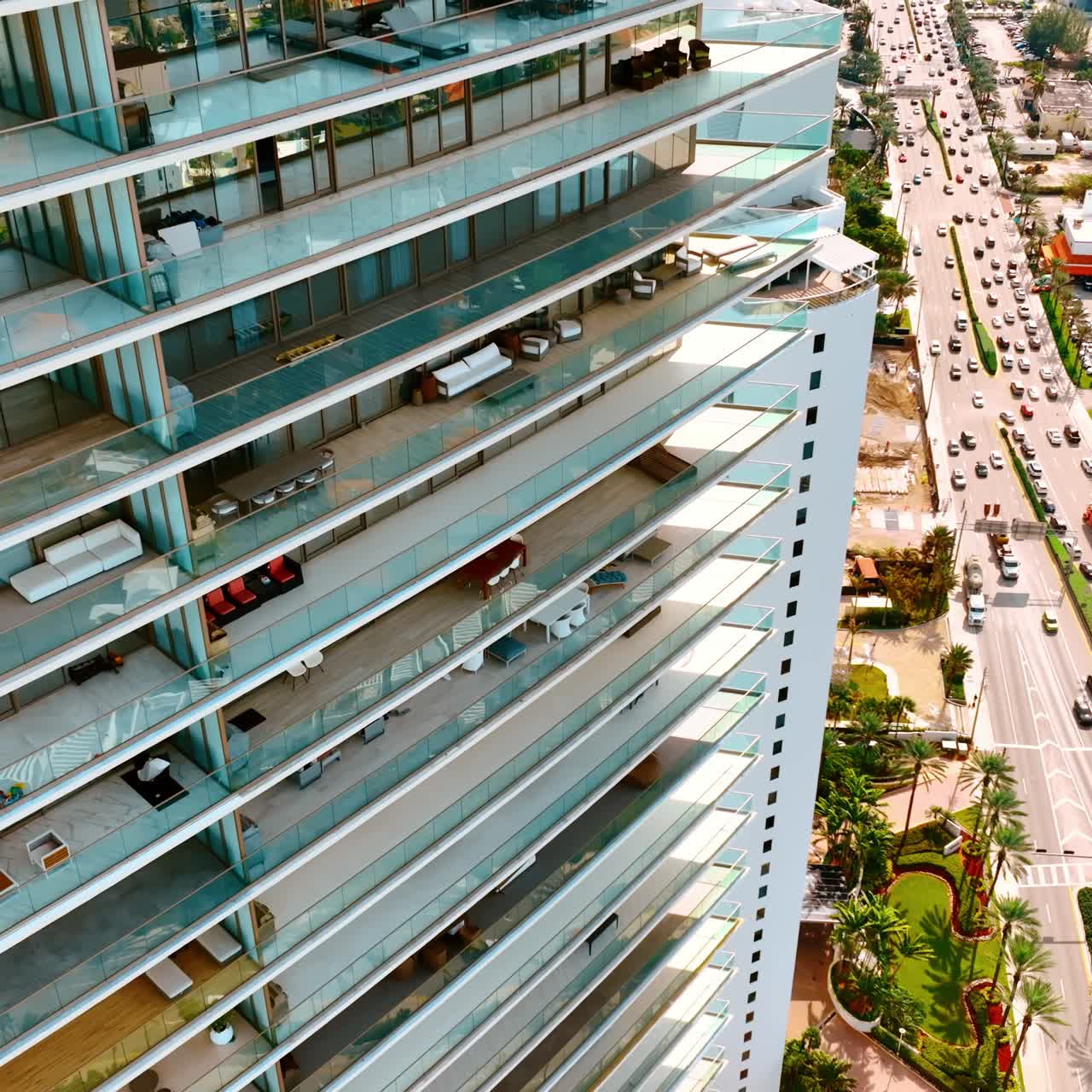 Vista cercana de la fachada de un moderno bloque de apartamentos de gran altura. Dron ascendiendo a lo largo de los balcones acristalados. Miami Beach, Florida, EE. UU.
