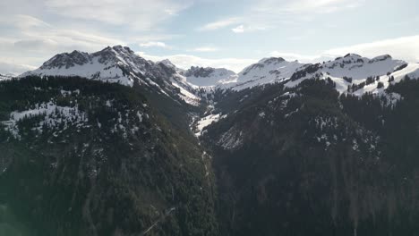 the scenic landscape of the mountain range in tirol tannheimer tal, switzerland, where snow blankets the peaks and forests intersect, showcasing the natural allure of the swiss countryside