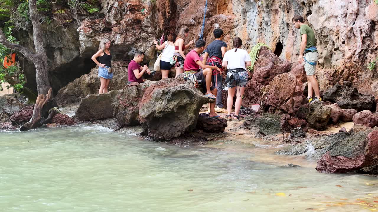 personas escalando rocas junto al mar en tailandia