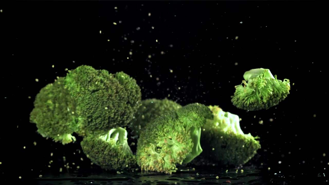 Cimette di broccoli freschi e verdi che cadono al rallentatore