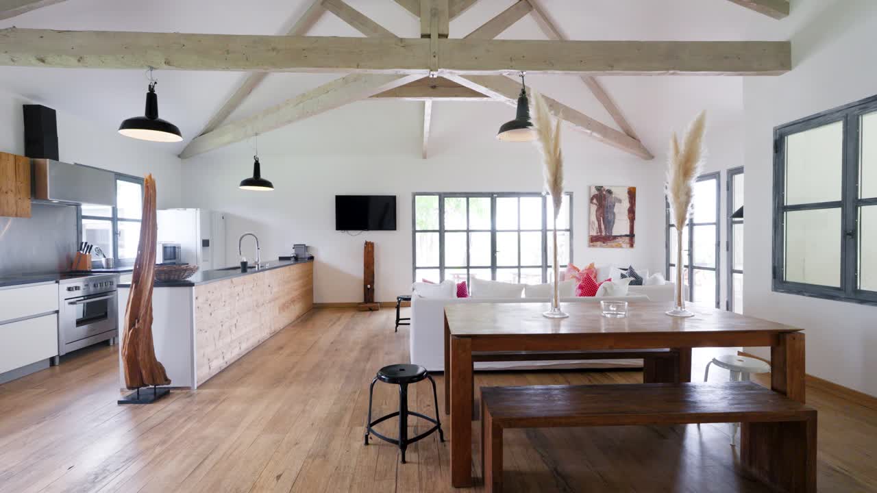 Slow closing shot of a minimal wooden kitchen and dining area with a villa