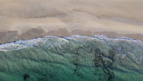 Drone-aerial-panning-up-from-a-beautiful-beach-to-a-national-park-full-of-trees