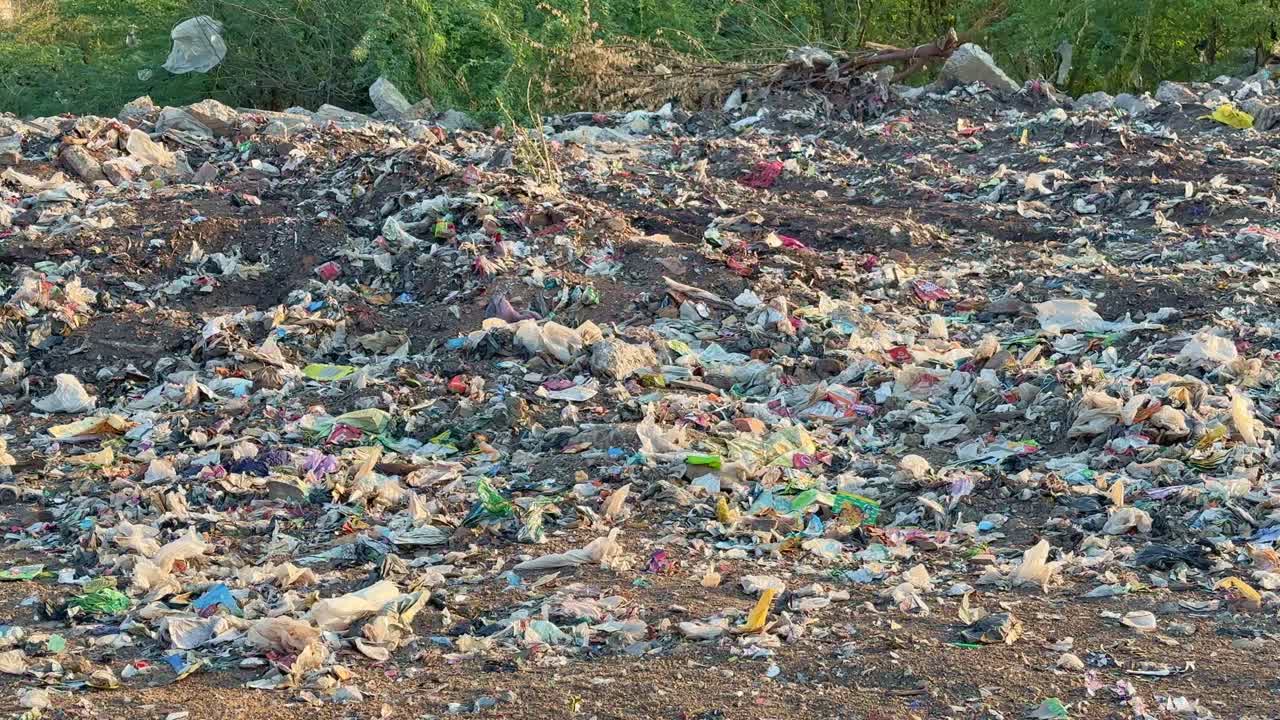 Closeup of the land filling dump yard filled with plastic bags and other garbage