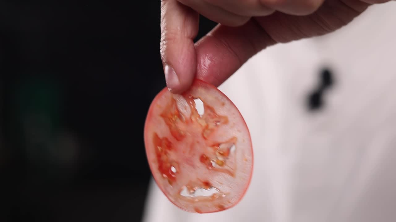 게 잘라진 토마토를 들고 있는 요리사