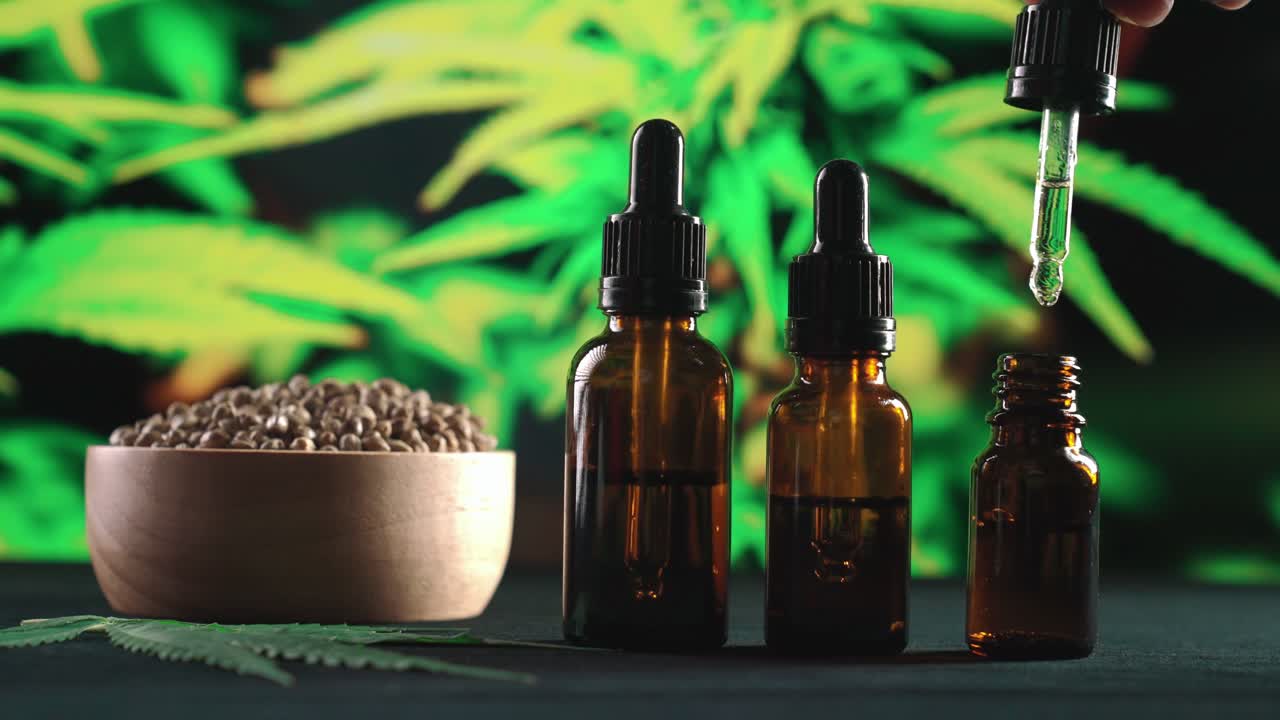 손 압력 피 ⁇  cbd 오일이 합법화 된 대마초 오일 병에 떨어집니다.