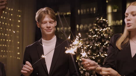 Close-Up-View-Of-Group-Of-Friends-Wearing-Stylish-Clothes-Dancing-And-Holding-Sparklers-At-New-Year's-Eve-Party-1