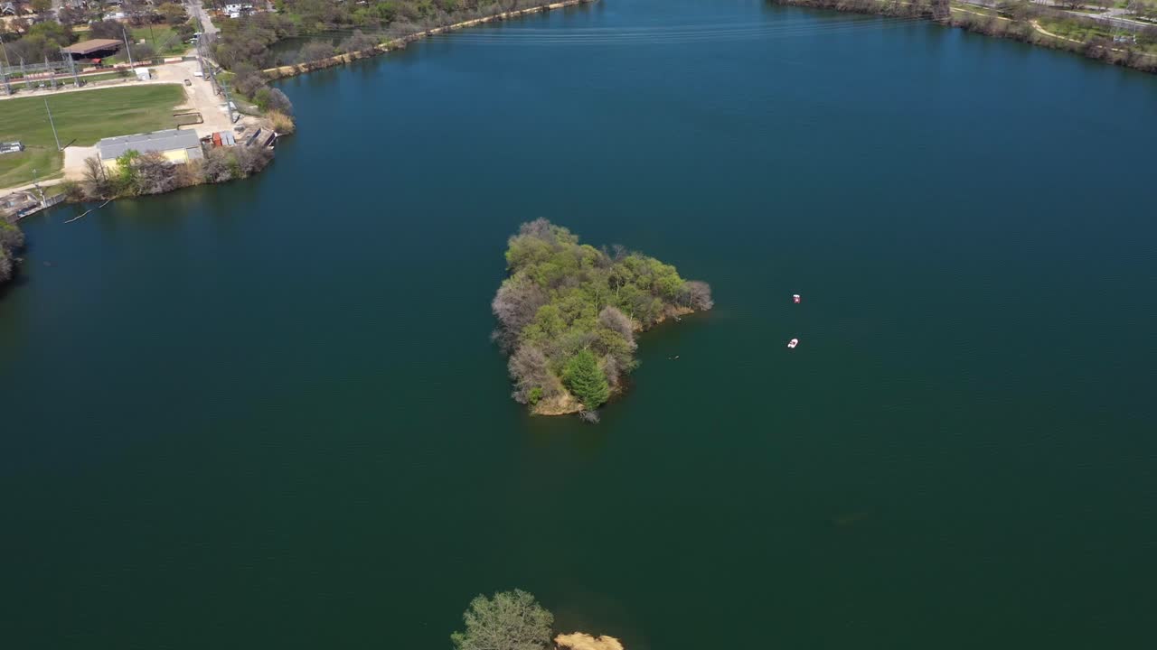 Small Island sitting on the lake with boats