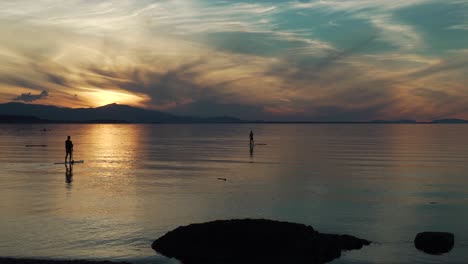 silueta de paddle surf al atardecer