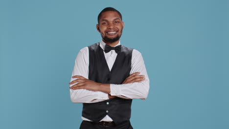 confident cheerful hotel concierge staff poses with arms crossed in studio