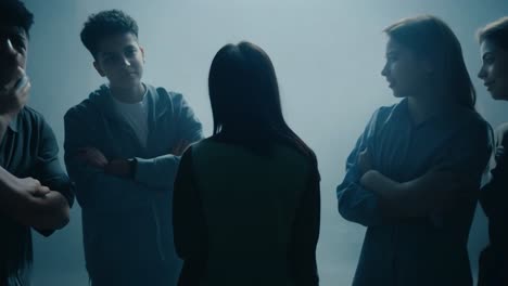 group of young people talking in a foggy room