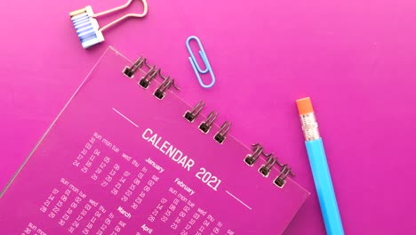 2021 calendar with office supplies on purple desk