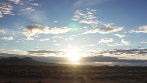 Aerial-view-of-the-rugged-terrain-of-the-Mojave-Desert-at-sunrise---lens-flare