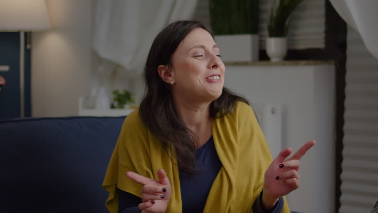 amigos de raza mixta charlando durante la fiesta nocturna mientras están sentados en el sofá