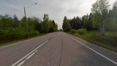 The-road-serves-as-a-lifeline,-connecting-the-village-to-the-outside-world,-while-the-trees-provide-a-natural-backdrop-to-the-scene