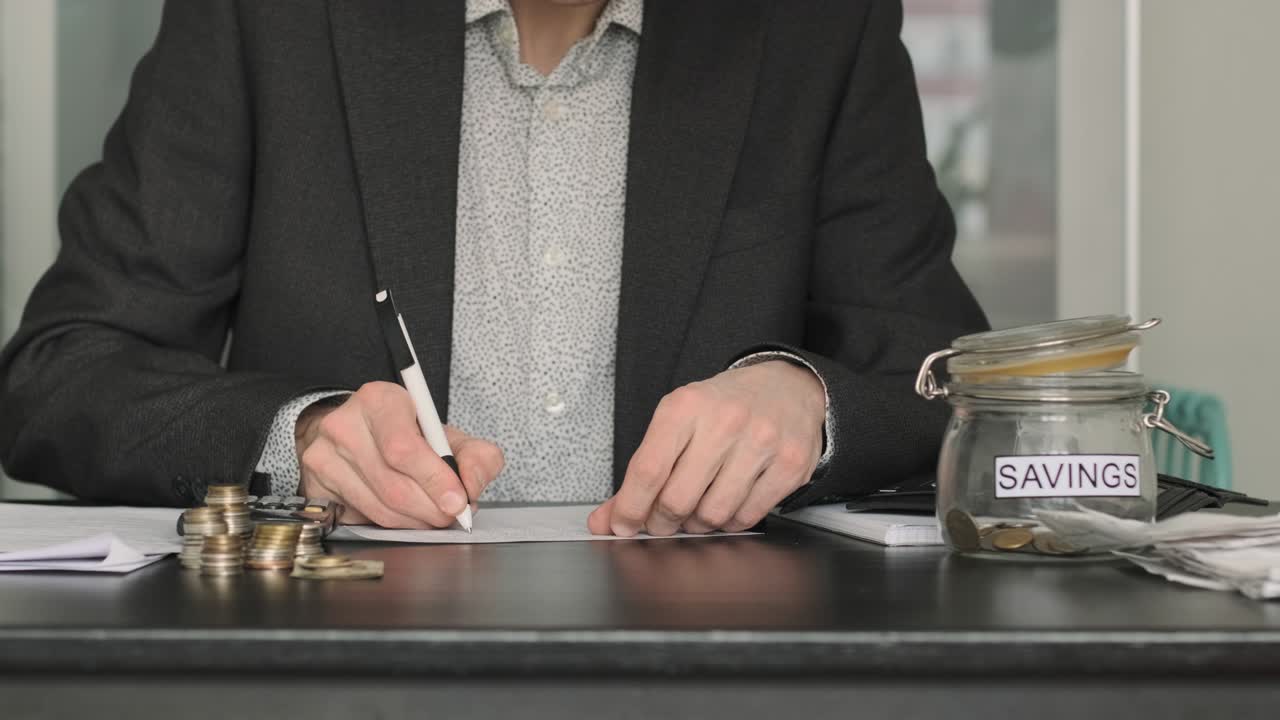 男性が机の上に財布からコインを注ぐ