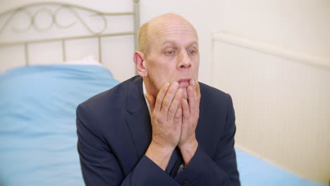 a mature businessman alone in a bedroom