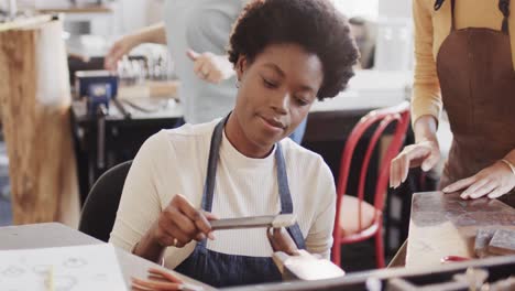 Busy-diverse-female-workers-shaping-ring-with-handcraft-tools-in-studio-in-slow-motion