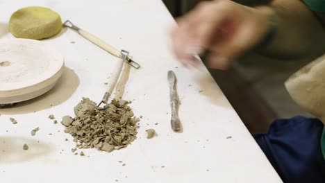 Close-up-shot-of-a-craftsman-sculpting-clay-with-ceramics-in-a-workshop