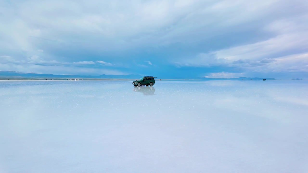 Dataran Garam Salar de Uyuni Bolivia dengan Kendaraan Off-Road dan Refleksi Awan.