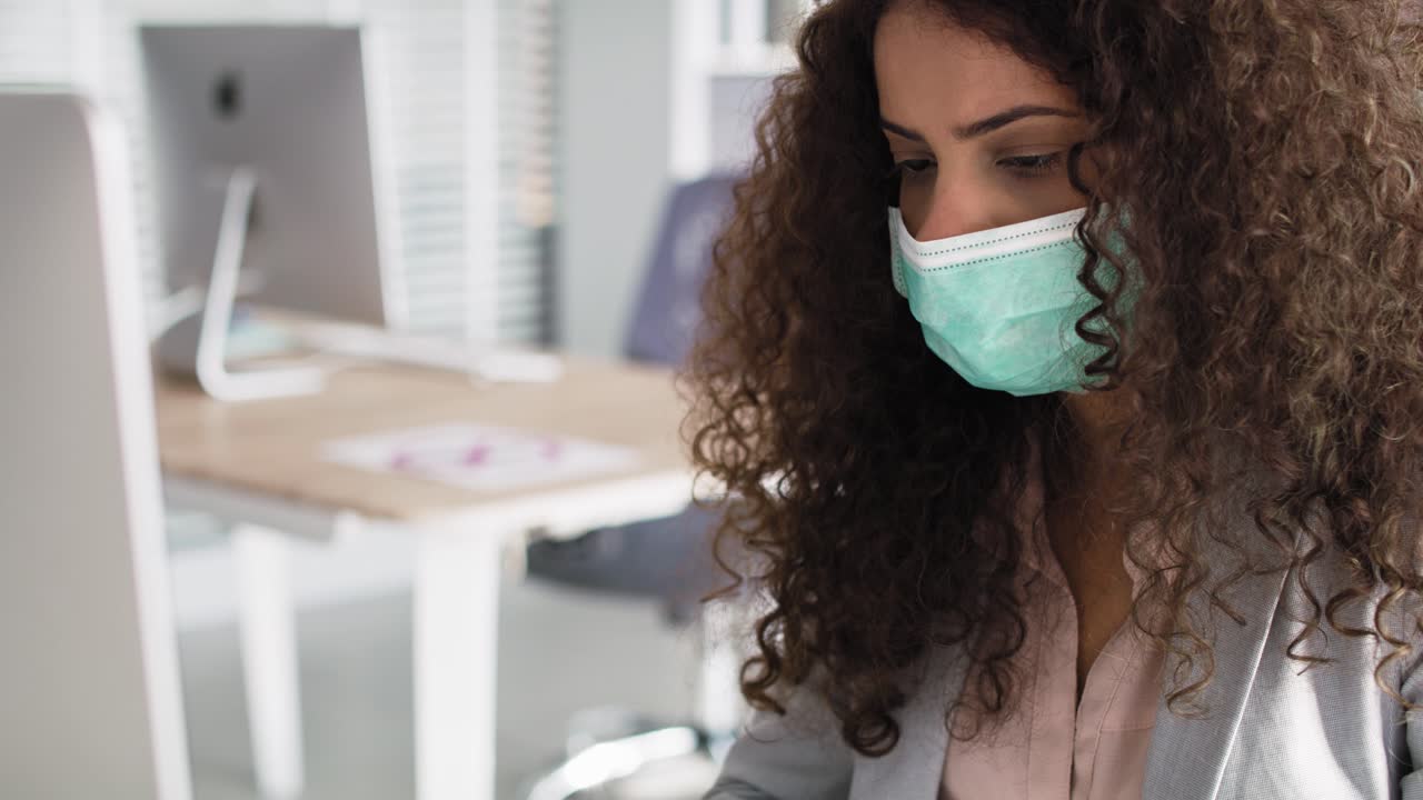 Video of woman in protective mask working in the office