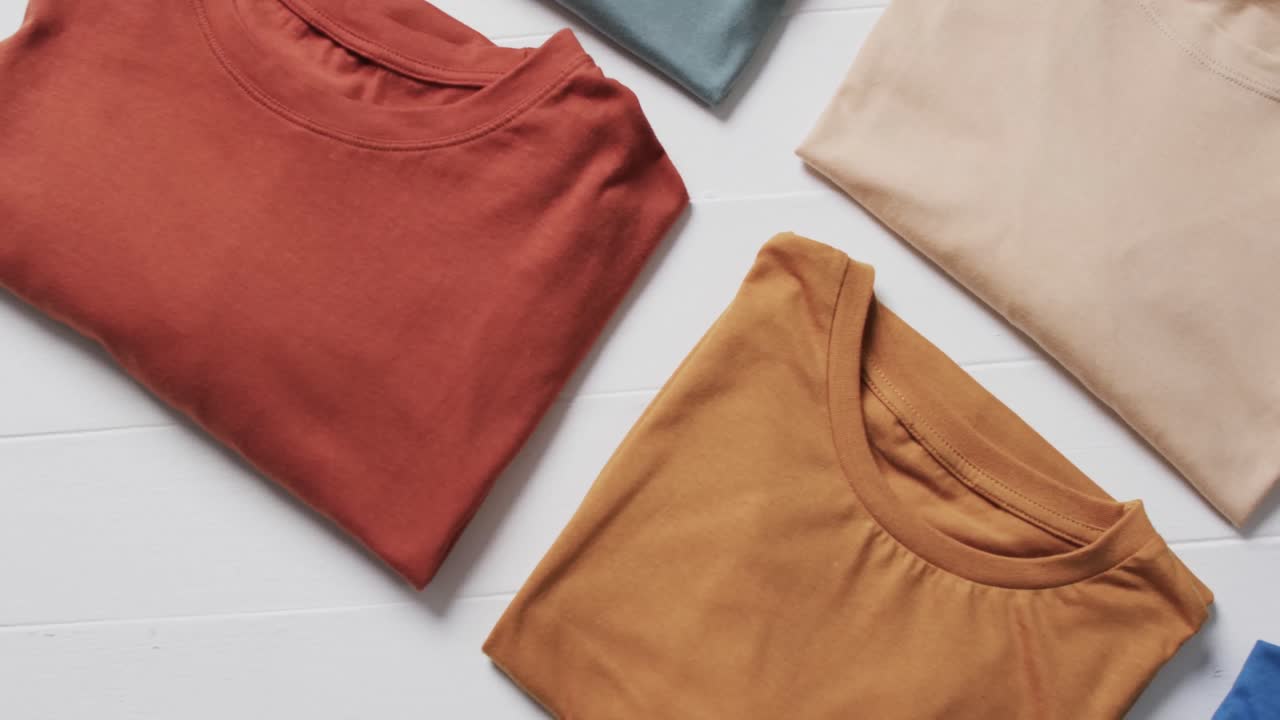 video de una capa plana de camisetas multicolores con espacio de copia sobre un fondo blanco