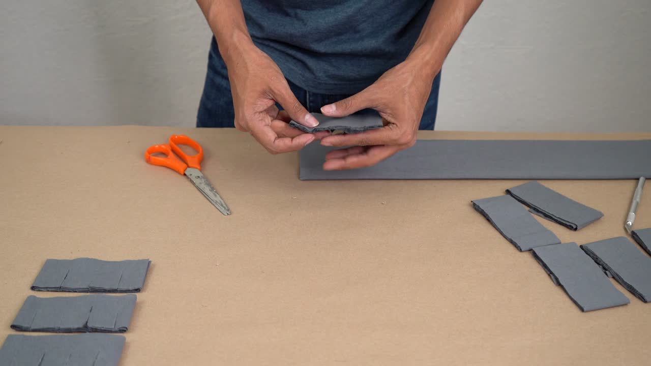 Workshop scene showing craftsman measuring crepe paper after it has been cut