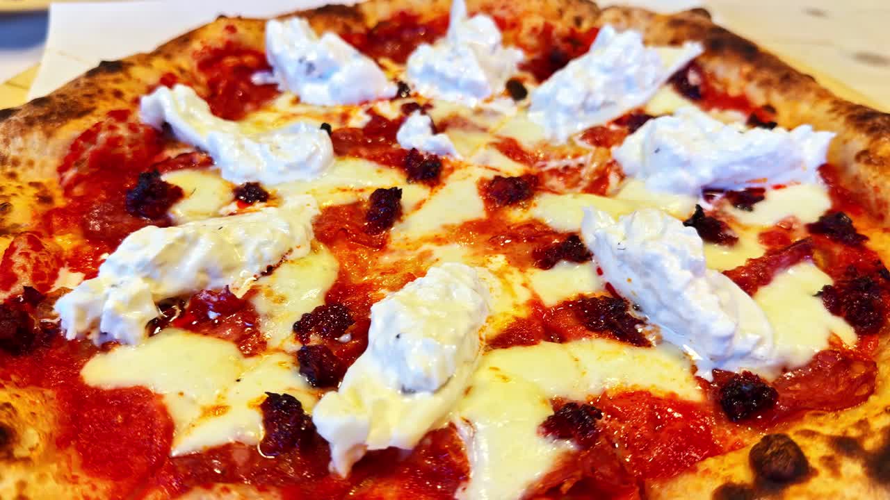 Primo piano di una pizza con base di passata di pomodoro e ricotta