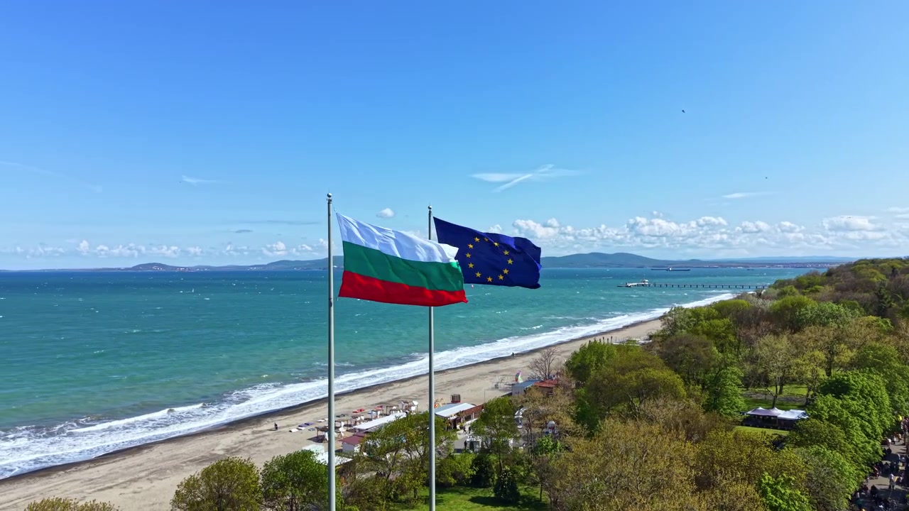 Bandiere della Bulgaria e dell'Unione Europea che sventolano su una spiaggia in Bulgaria con vista sul mare e sulla costa in una giornata di sole