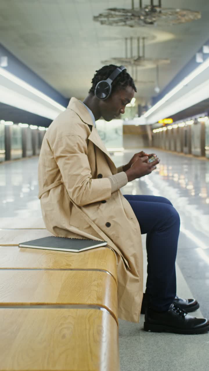 Man Using Phone in Subway Station