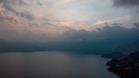 在危地马拉阿蒂特兰湖的云层后面美丽的日落的无人机空中超速拍摄