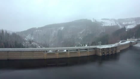 a flight over a dike with a road that tourists walk on a cold snowy morning in winter