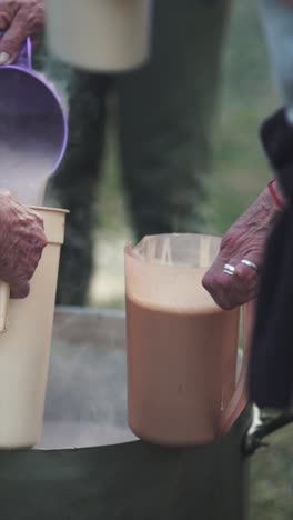 boiling chocolate milk poured from a hot pan into a can